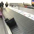 A Stansted baggage claim: people wait as a lonely bag goes around and around