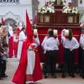 A penitente, with a red Capirote, looks around, An Easter Parade, Nerja, Andalusia, Spain - 21st April 2019