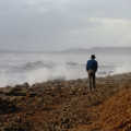 Sean walks along a stormy beach
