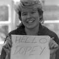Jo holds up a 'hello Dopey' sign, Learning Black-and-White Photography, Brockenhurst College, Hampshire - 10th March 1985