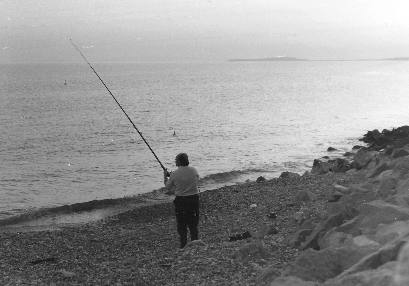 Some dude fishes off Barton beach from Life in Ford Cottage and Barton on Sea, Hampshire - 2nd April 1985