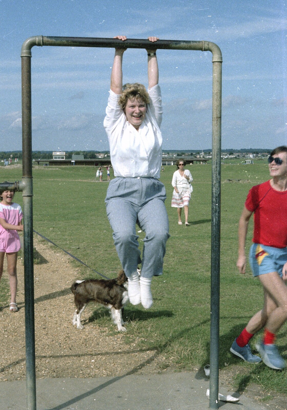 Anna swings from the monkey bars from Brockenhurst College Exams and Miscellany, Barton on Sea, Hampshire - 10th June 1985