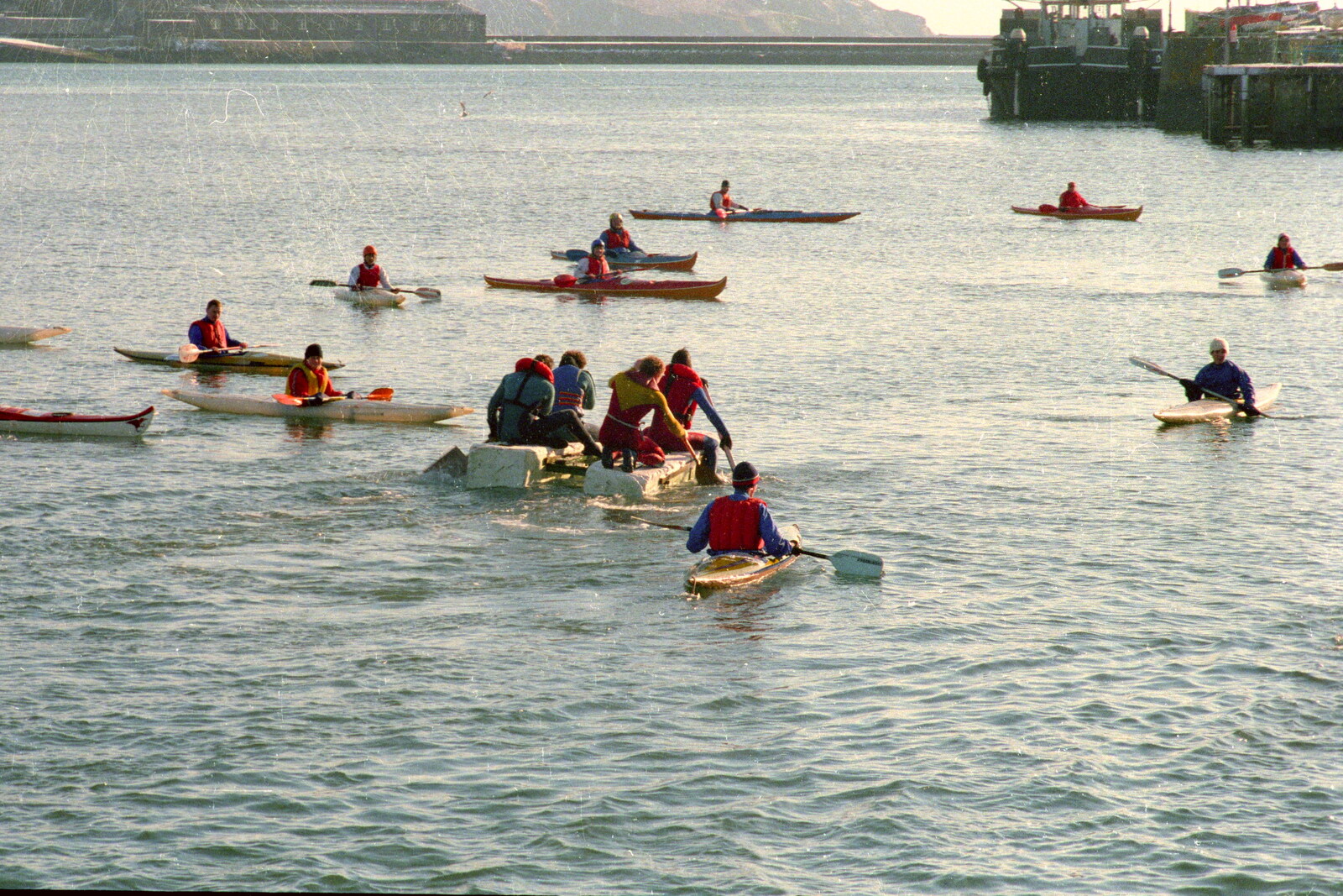 Rafts paddle out to Plymouth Sound, surrounded by canoes from Uni: Canoe Society RAG Raft Madness, Plymouth Sound - 1st March 1986