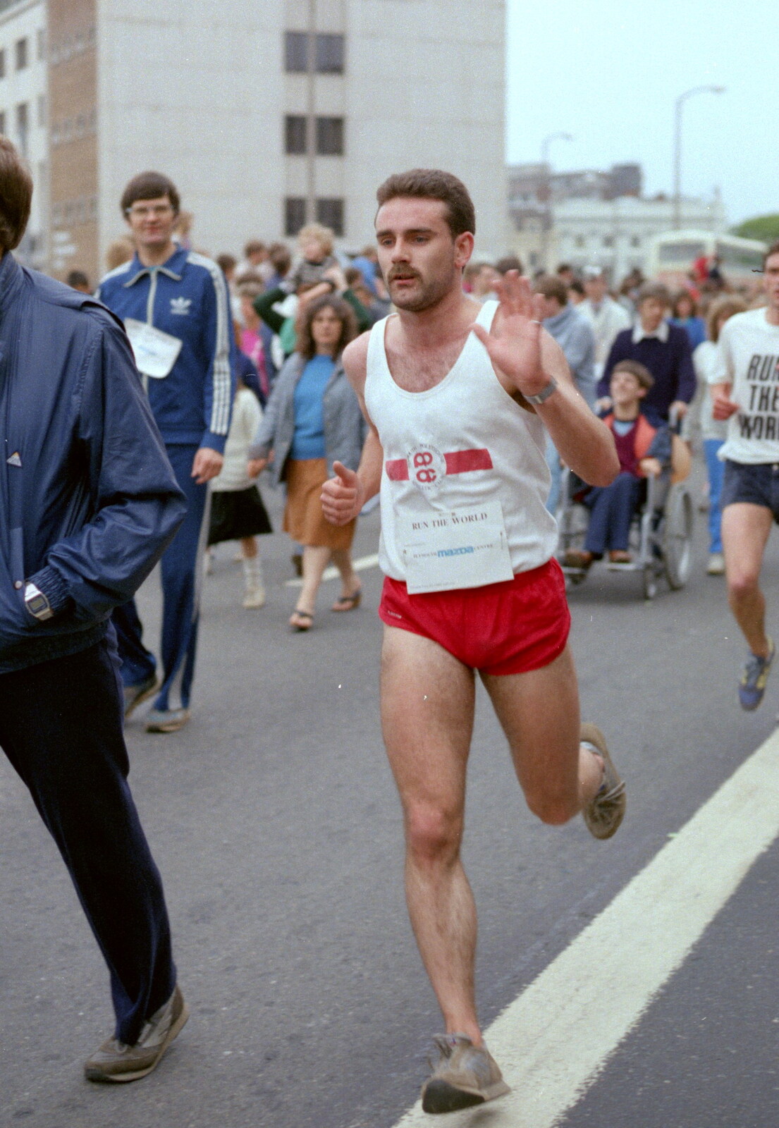 Mark, off of Phsychology, waves on his way round from Uni: Sport Aid - Run The World, Plymouth, Devon - 25th May 1986