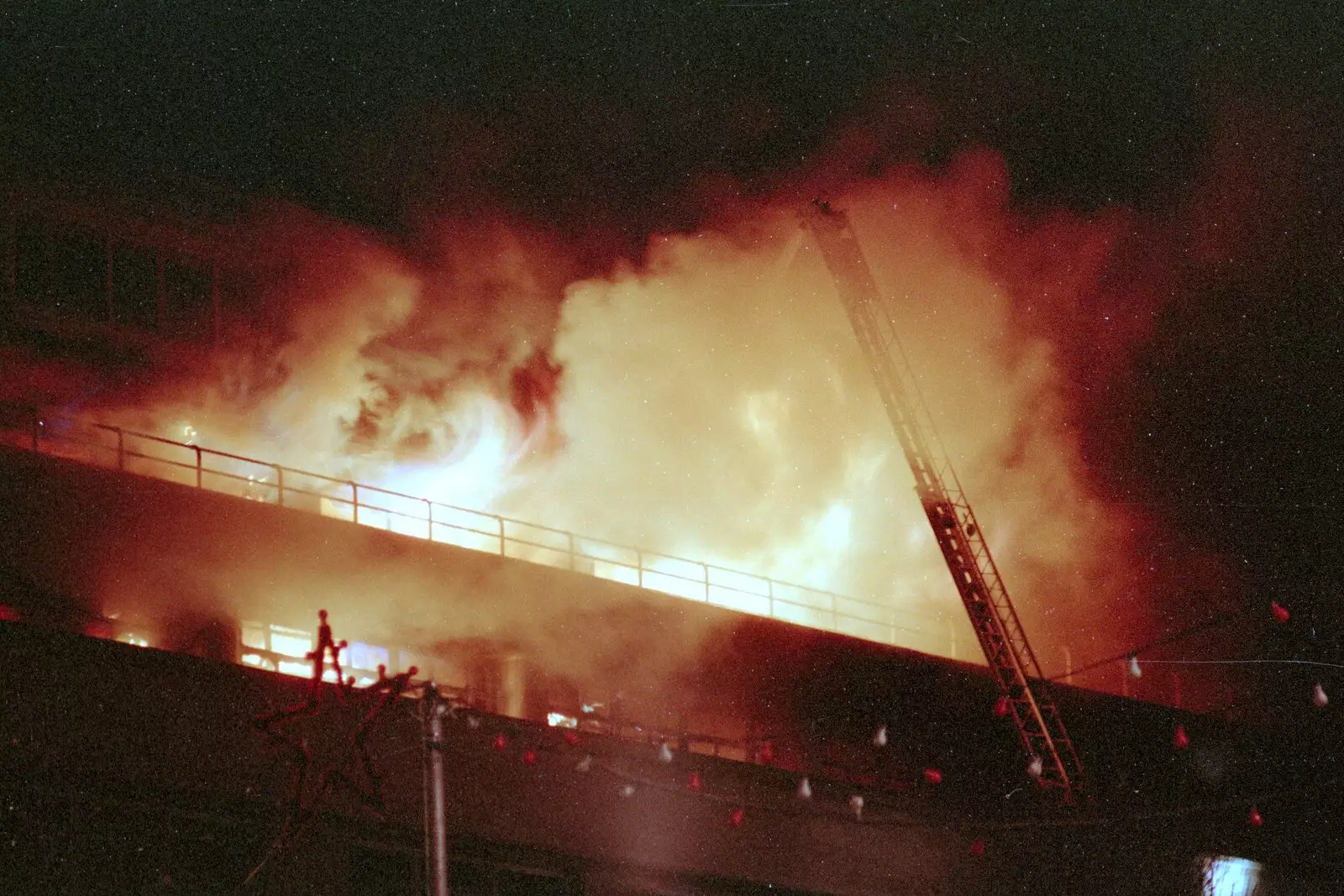 Flames curl out of the top floor, from Uni: The Fire-Bombing of Dingles, Plymouth, Devon - 19th December 1988