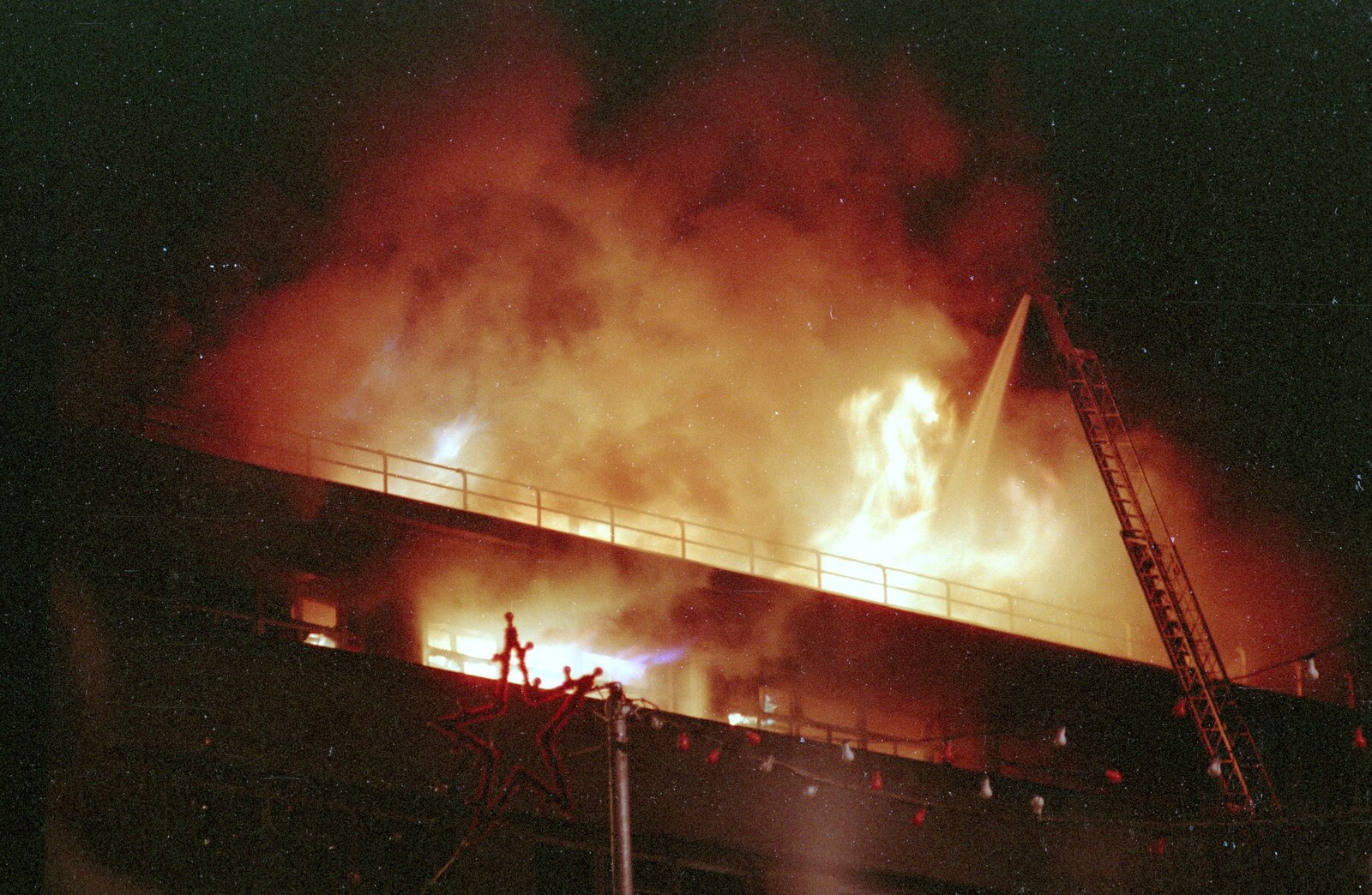 A fire hose sprays down into the flames from Uni: The Fire-Bombing of Dingles, Plymouth, Devon - 19th December 1988