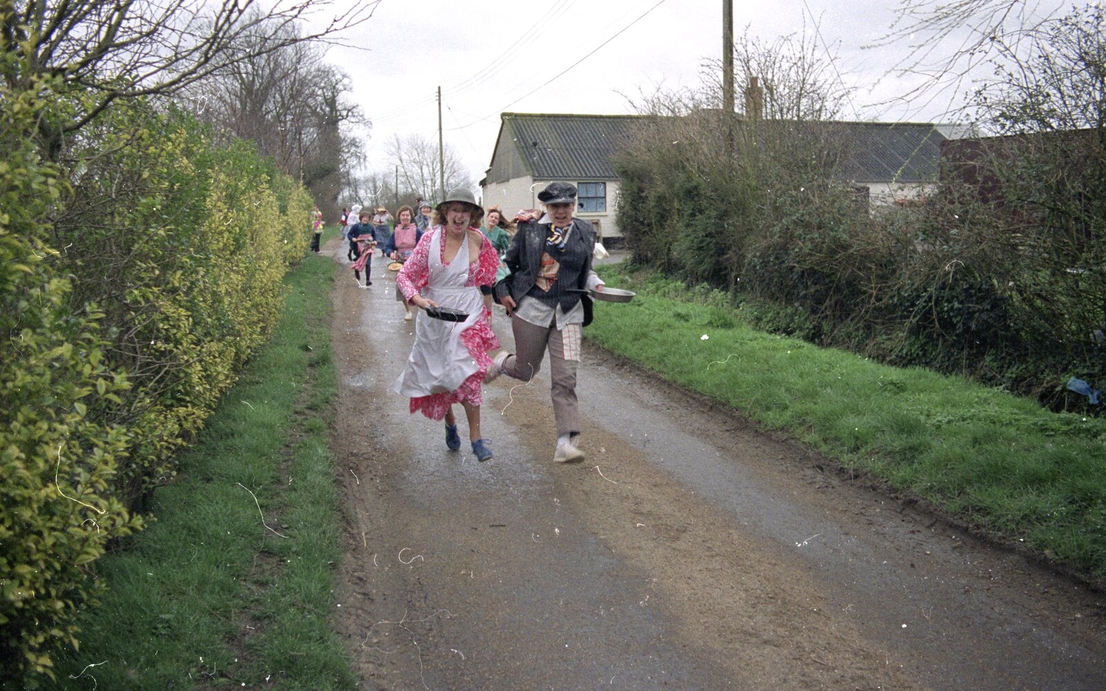 Elteb and Kim Archer run for it from Pancake Day in Starston, Norfolk - 27th February 1990