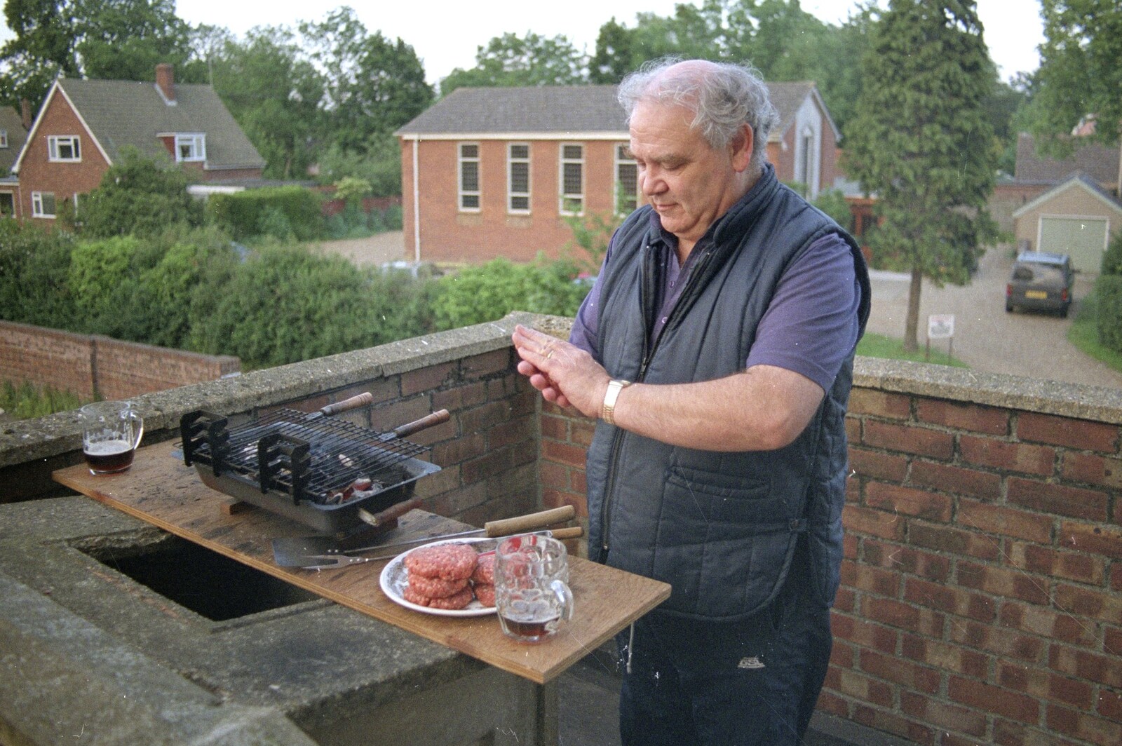 Kenny pats some burgers together on his balcony from An "Above The Laundrette" Barbeque, Diss, Norfolk - 28th May 1990