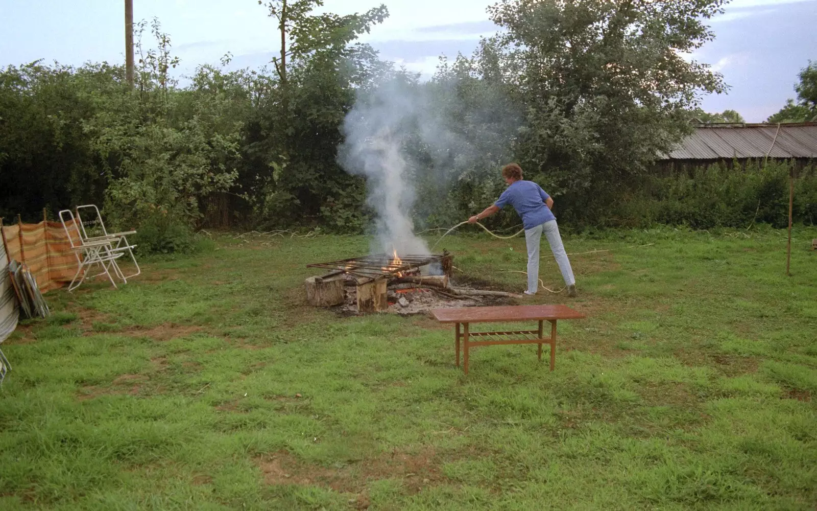 Brenda squirts the fire with a hosepipe, from Sue's Fire Dance, Stuston, Suffolk - 21st July 1990