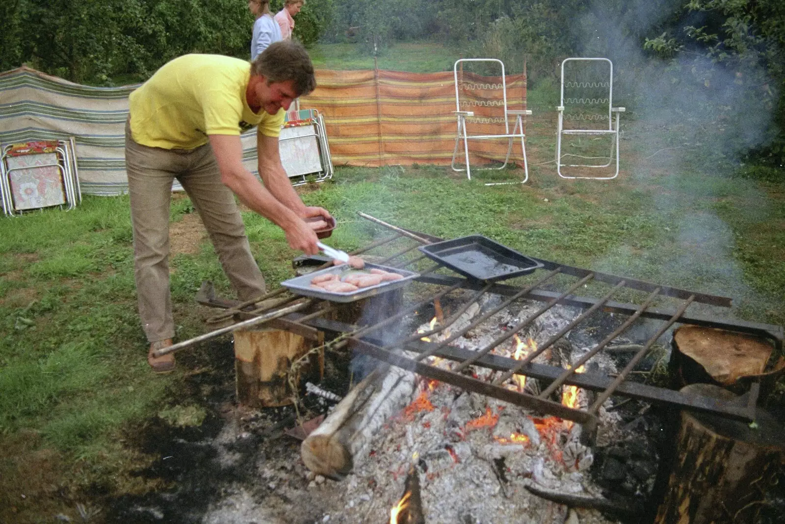 Geoff chucks some sausages on, from Sue's Fire Dance, Stuston, Suffolk - 21st July 1990