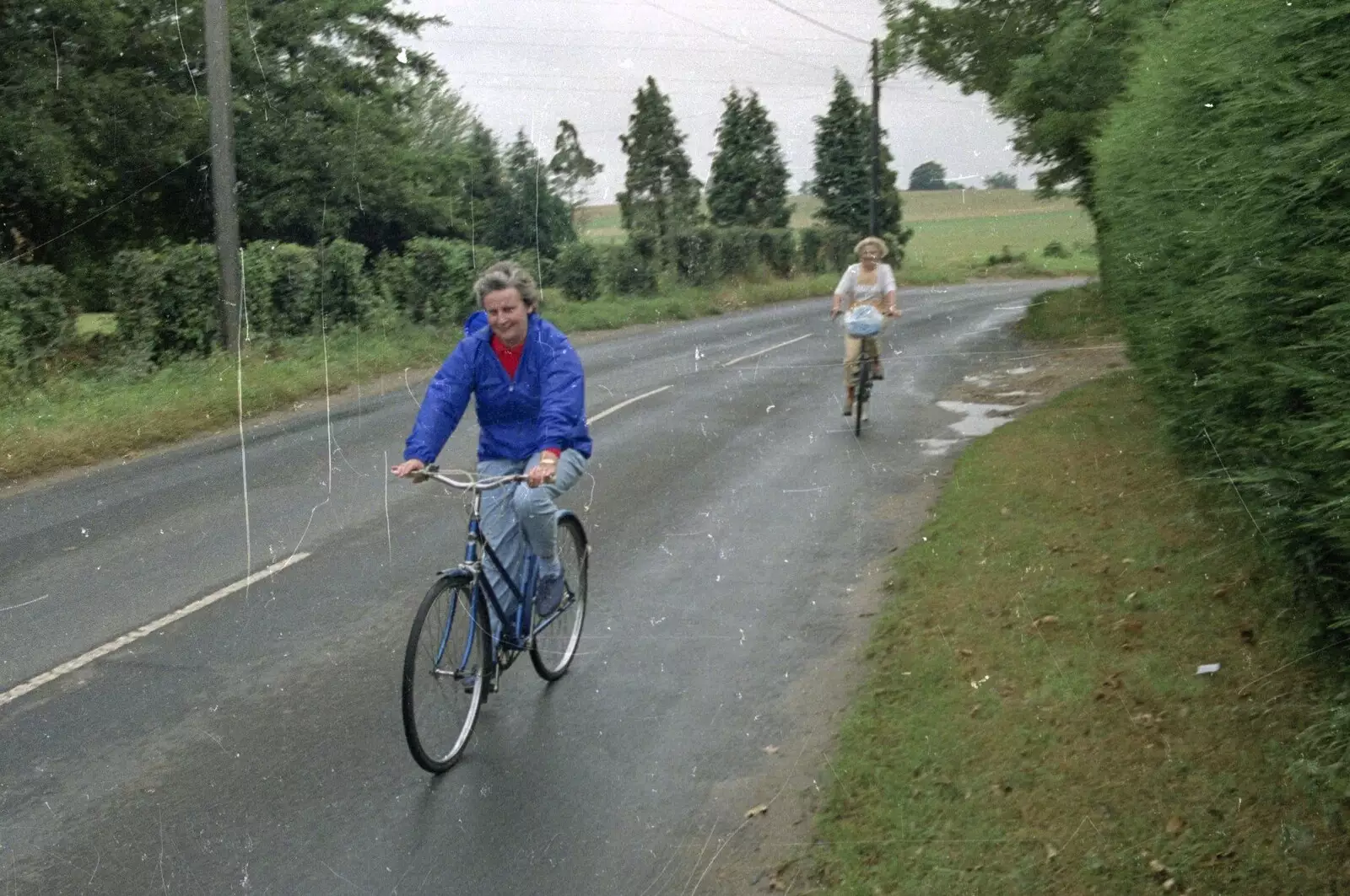 Linda peddles past, from A Bike Ride to Redgrave, Suffolk - 11th August 1990