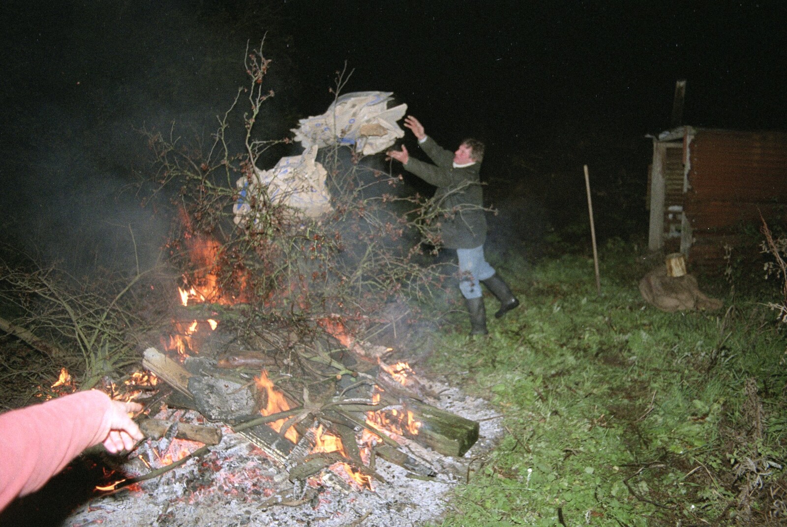 Geoff chucks some more fuel on to the fire from Bonfire Night, Stuston, Suffolk - 5th November 1990