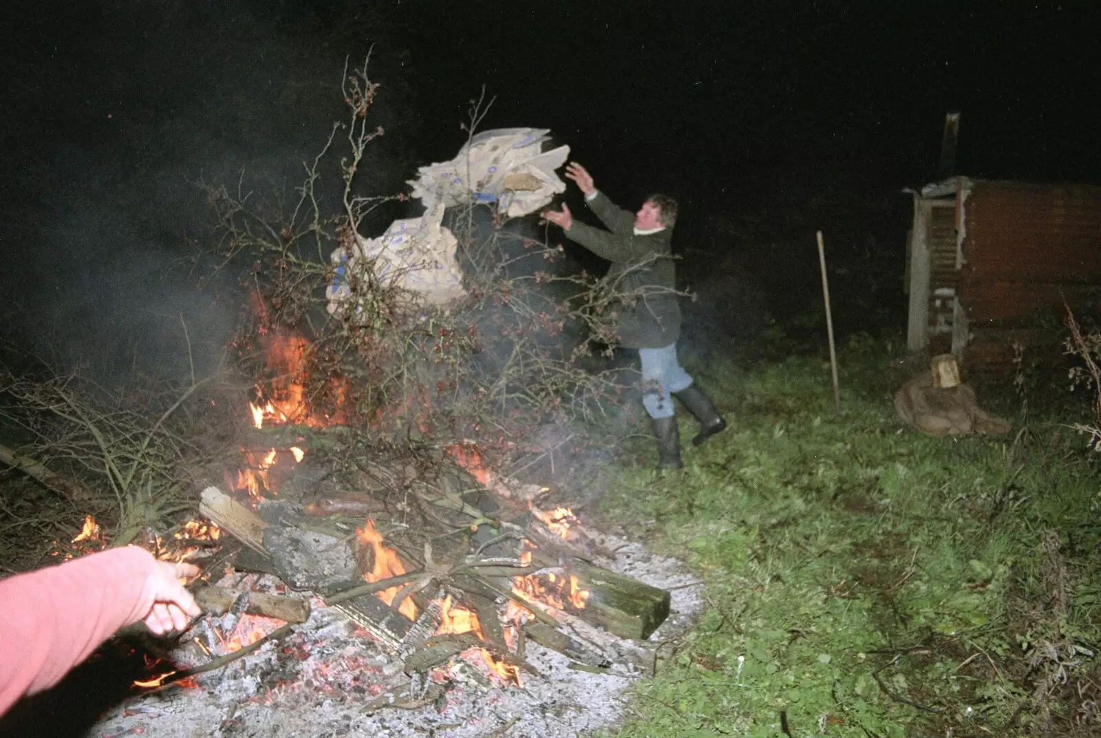 Geoff chucks some more fuel on to the fire, from Bonfire Night, Stuston, Suffolk - 5th November 1990