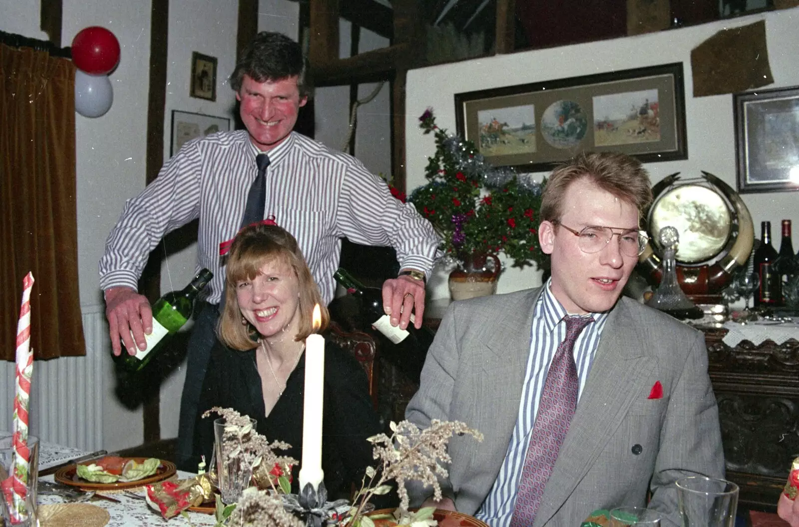 Geoff sticks bottles of wine in Janet's ears, from Christmas Dinner with Geoff and Brenda, Stuston, Suffolk - 25th December 1990