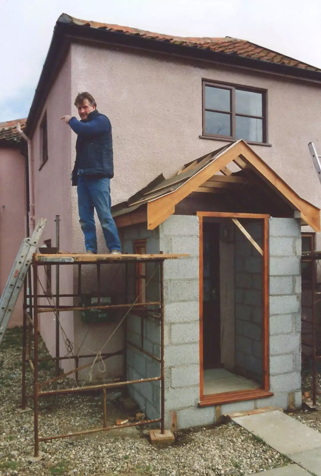 Bernie stands on scaffolding an points, from Bernie and the Porch, The Stables, Stuston, Suffolk - 15th March 1991