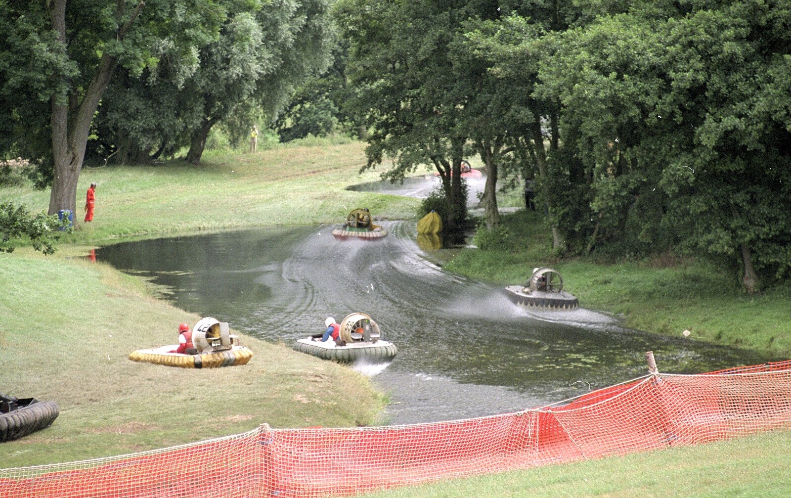 A bunch of hovercraft head down a flooded field from Riki and Dave in Chinatown, and Racing Hovercraft, London and Suffolk - 12th June 1991