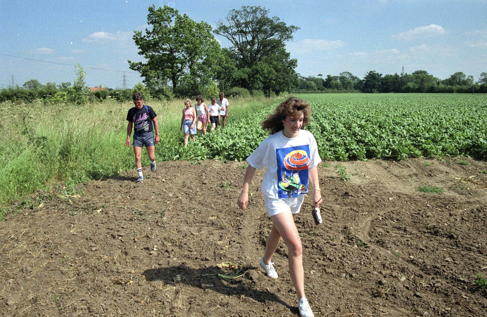 Monique strides across a field from A Walk to Thrandeston, Suffolk - 29th June 1991