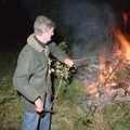 Geoff pokes the fire with a stick, Bonfire Night and Printec at the Stoke Ash White Horse, Suffolk - 5th November 1991