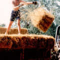 In Tibenham, Mike and Sue's eldest daughter hurls a bail of straw