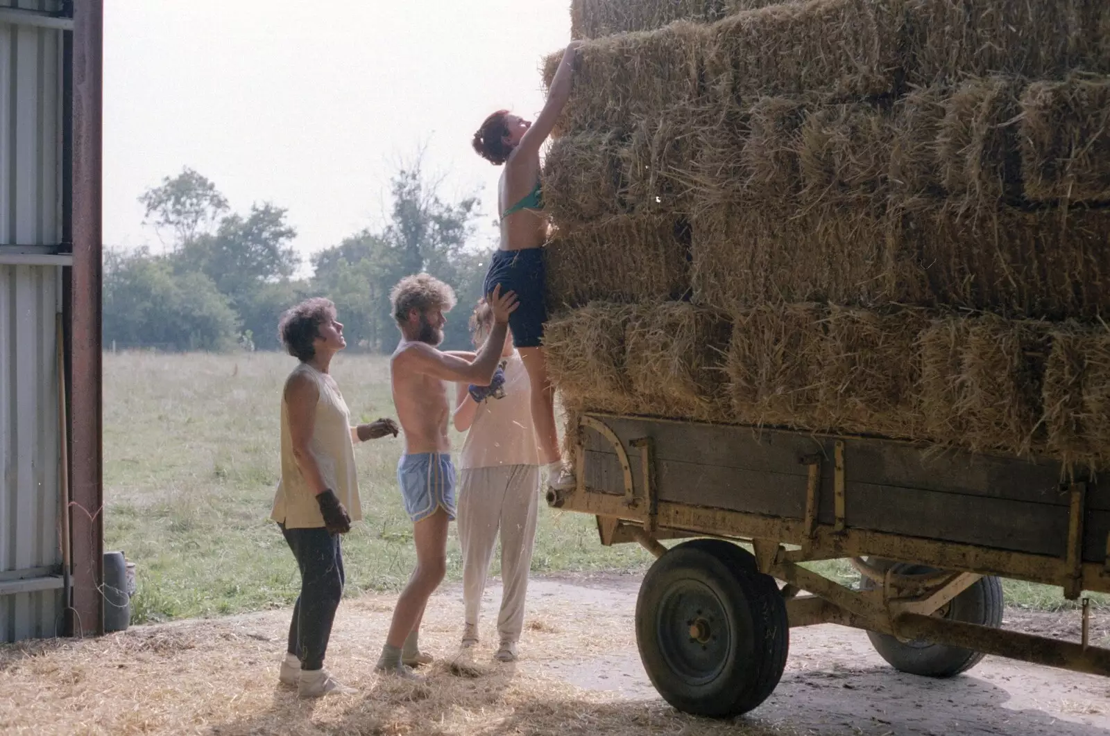 Sarah climbs to the top of the stack, from Working on the Harvest, Tibenham, Norfolk - 11th August 1992