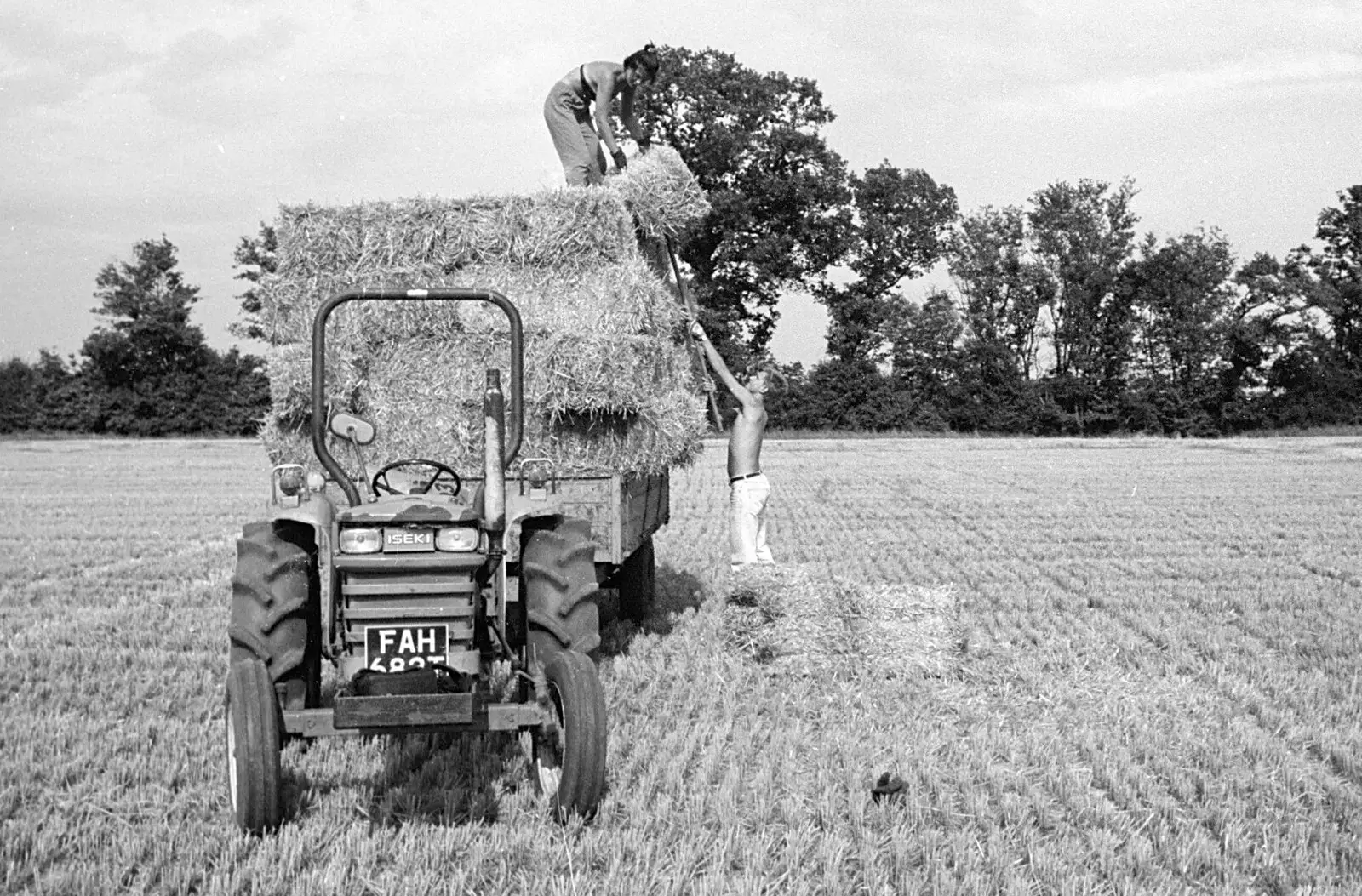 Nosher pitches a bale up to Sarah, from Working on the Harvest, Tibenham, Norfolk - 11th August 1992