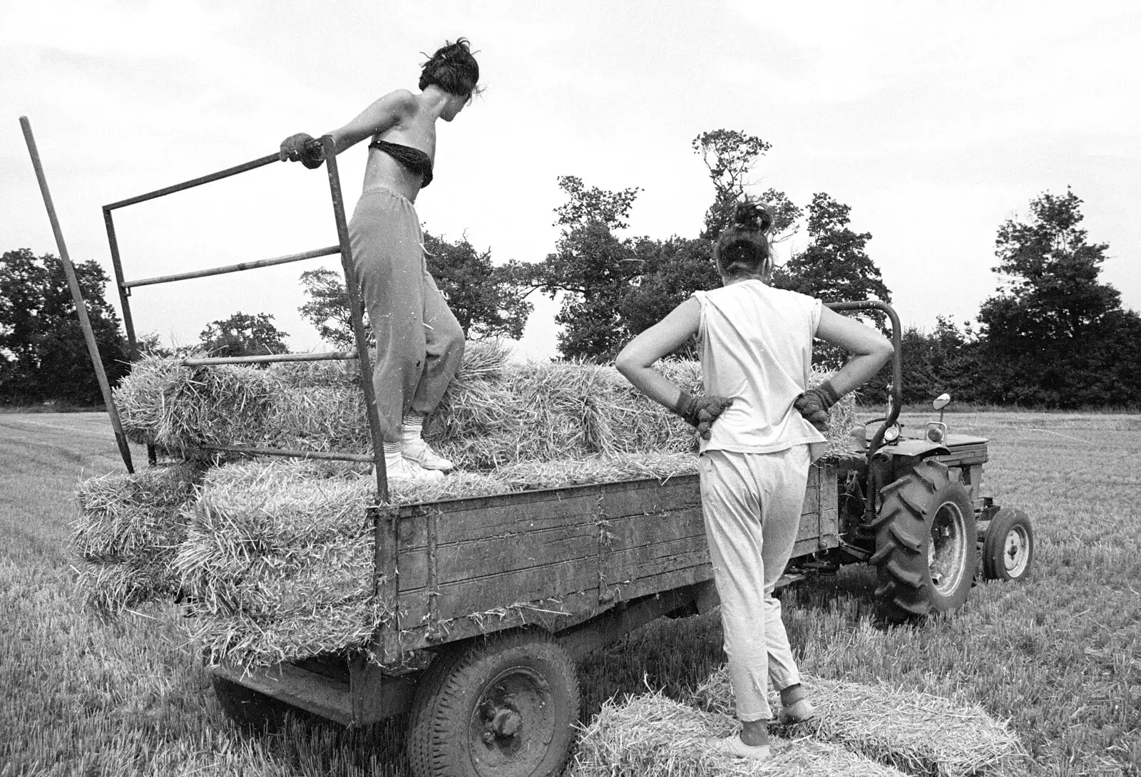 Rachel and Sarah consider the trailer, from Working on the Harvest, Tibenham, Norfolk - 11th August 1992