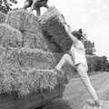 Rachel half-climbs up to shift a bale, Working on the Harvest, Tibenham, Norfolk - 11th August 1992