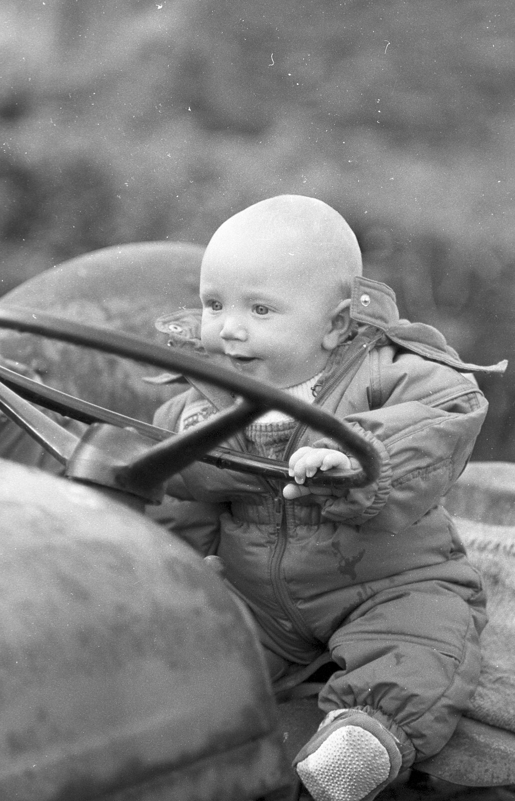 Monique's baby pretends to drive from Cider Making in Black and White, Stuston, Suffolk - 11th October 1992