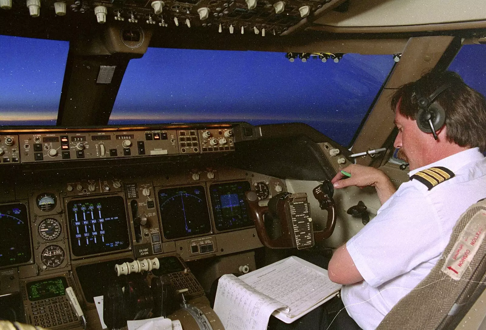 The co-pilot does paperwork at 35,000 feet, heading west, from A 747 Cockpit, Honolulu and Pearl Harbor, O'ahu, Hawai'i, United States - 20th November 1992