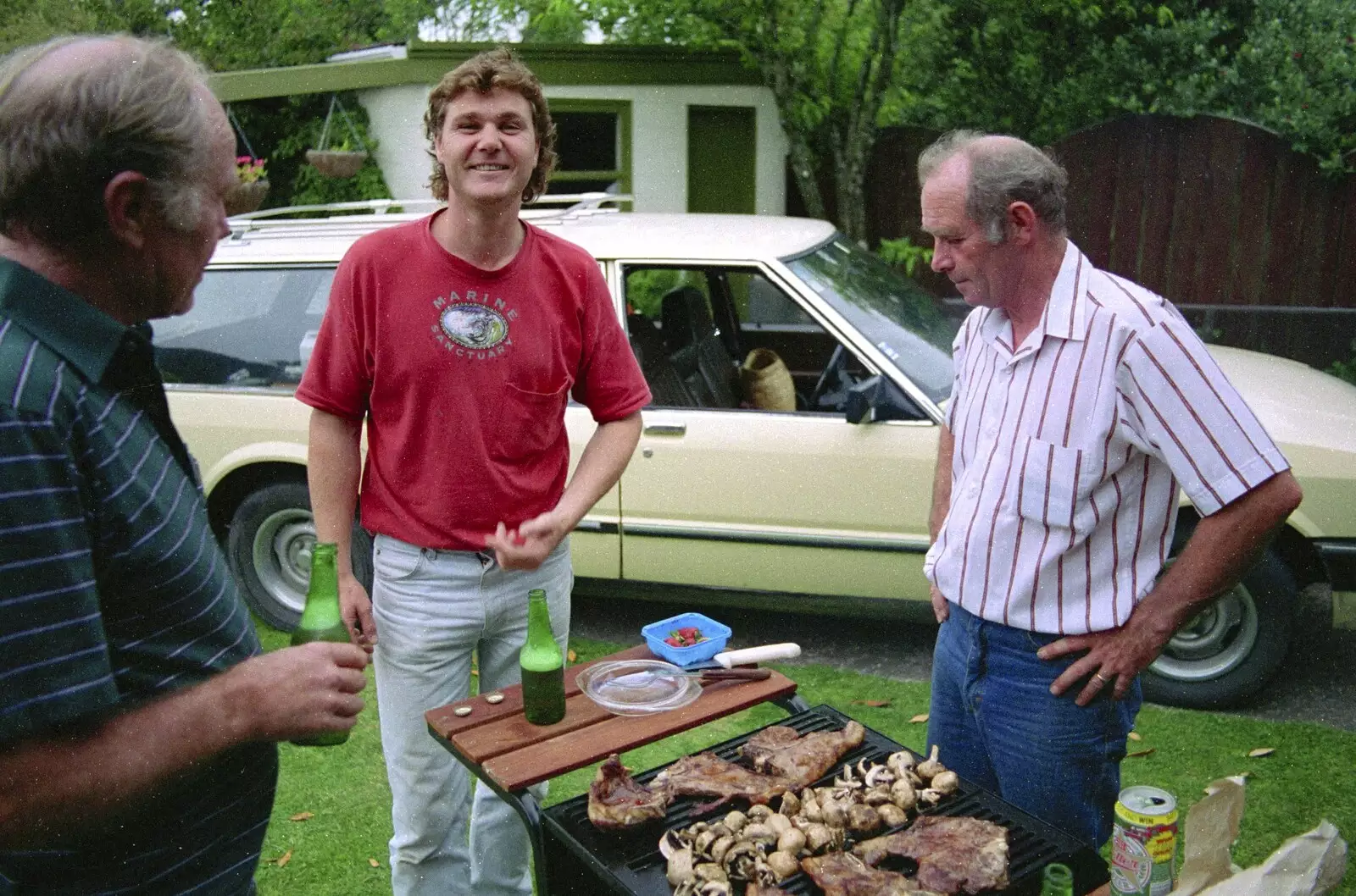 Steve grins as Clive inspects the barbeque, from Ferry Landing, Whitianga, New Zealand - 23rd November 1992