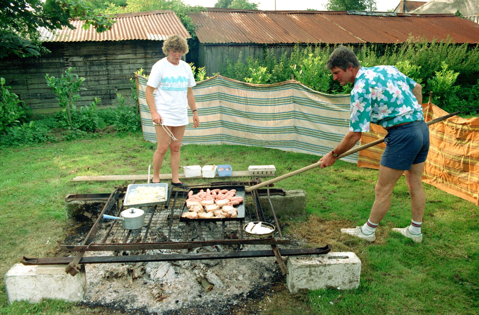 Geoff pokes the massive barbeque pit from A Geoff and Brenda Barbeque, Stuston, Suffolk - 3rd April 1994