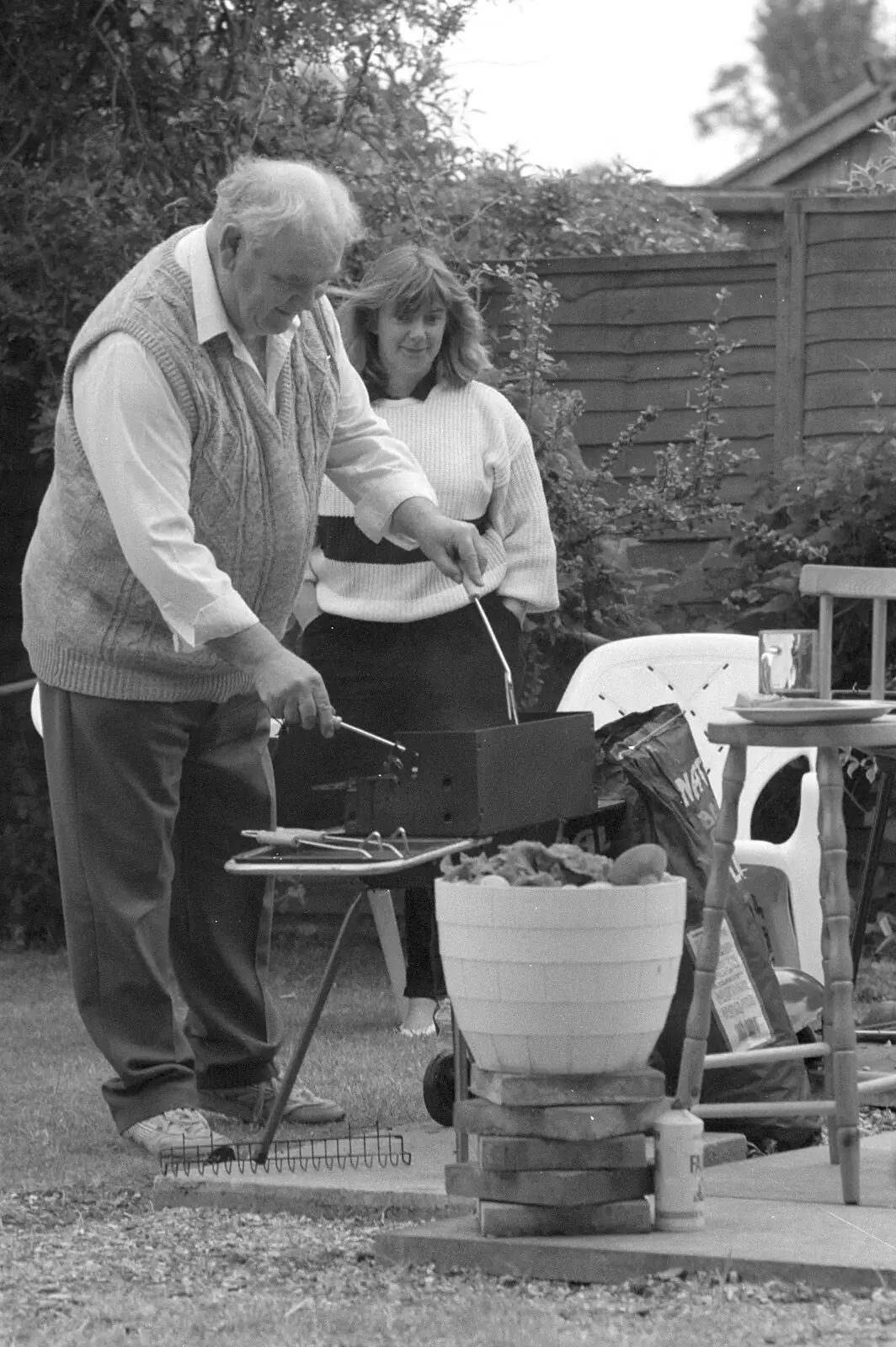 Kenny pokes at some sausages, from Sarah's Birthday Barbeque, Burston, Norfolk - 7th June 1994