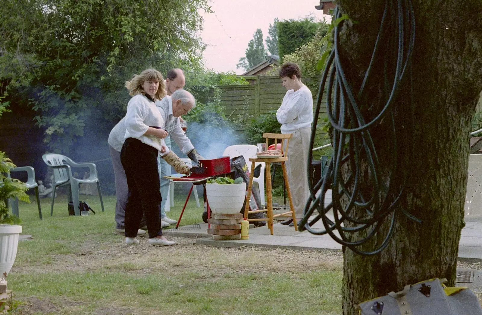 Sarah looks over as Kenny's barbeque smokes, from Sarah's Birthday Barbeque, Burston, Norfolk - 7th June 1994