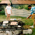 Geoff stokes up the barbeque pit with a long stick
