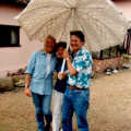 Sue, Brenda and Geoff huddle under a parasol