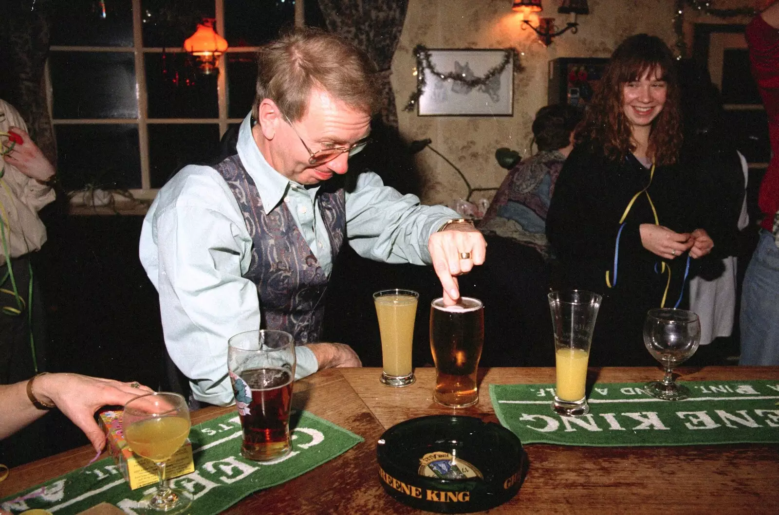 John Willy picks a paper disc out of his beer, from New Year's Eve at the Swan Inn, Brome, Suffolk - 31st December 1994