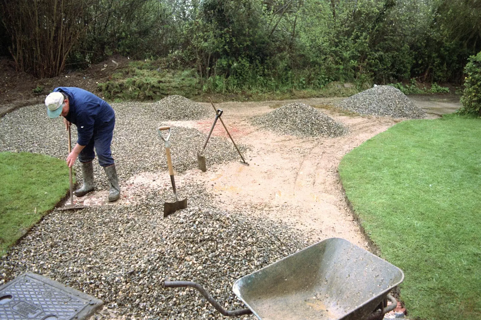 Danny rakes out gravel, from Garden Rotovator Action, Brome, Suffolk - 28th March 1998