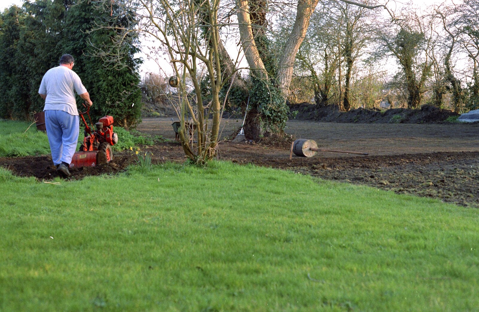 Danny trundles around rotovating the old lawn from Garden Rotovator Action, Brome, Suffolk - 28th March 1998