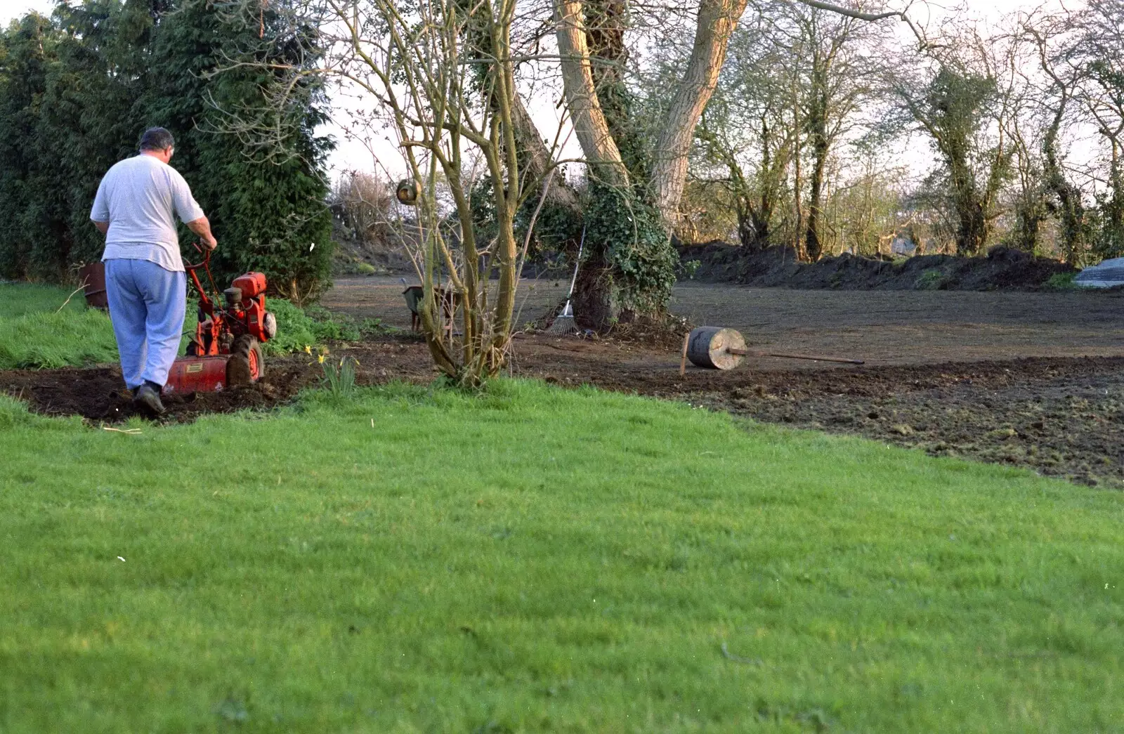 Danny trundles around rotovating the old lawn, from Garden Rotovator Action, Brome, Suffolk - 28th March 1998