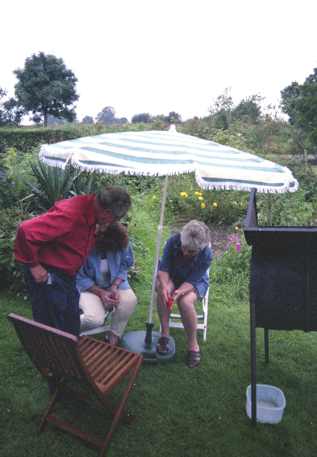 There's more fiddling with the parasol from A Mortlock Barbeque and a CISU Party, Suffolk - 11th July 1999