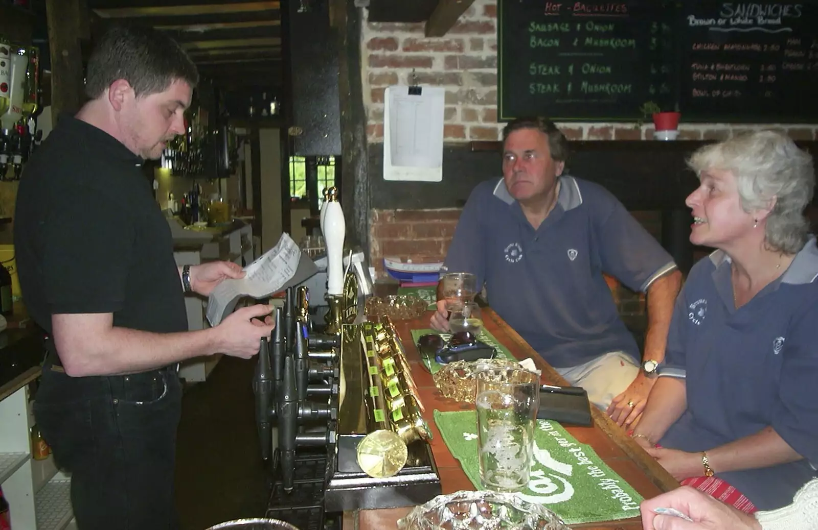 The bar dude checks a menu, from The BSCC Annual Bike Ride, Marquess of Exeter, Oakham, Rutland - 12th May 2001