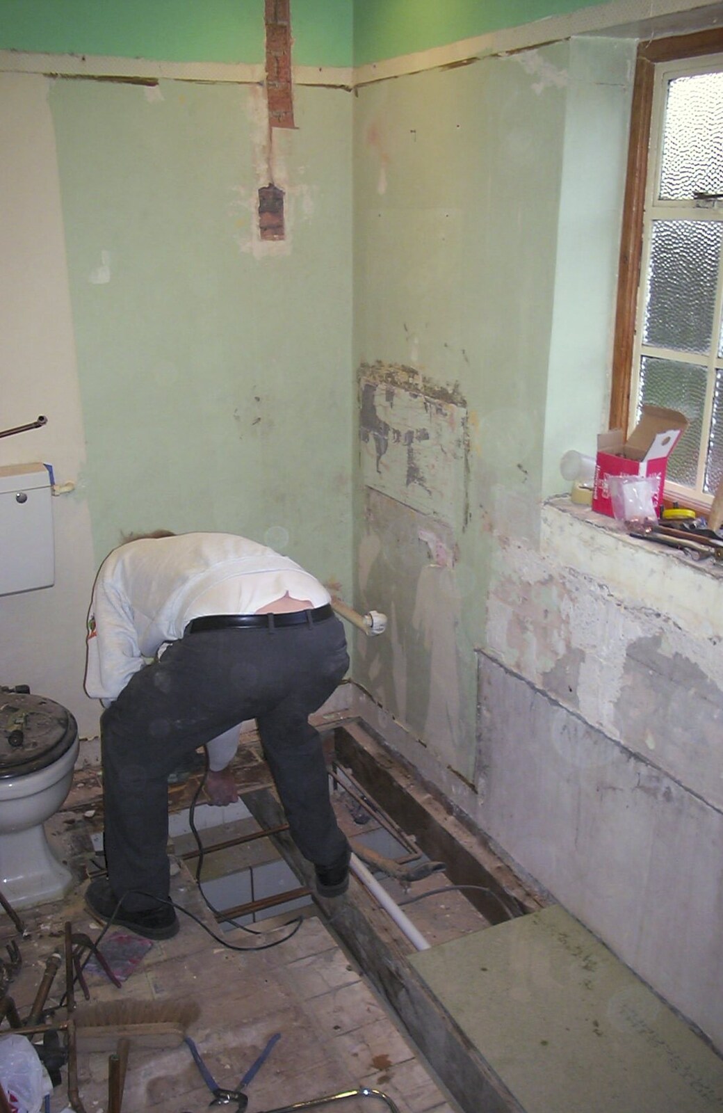 The old chap works over a hole in the floor from Bathroom Rebuilding, Brome, Suffolk - 1st February 2002