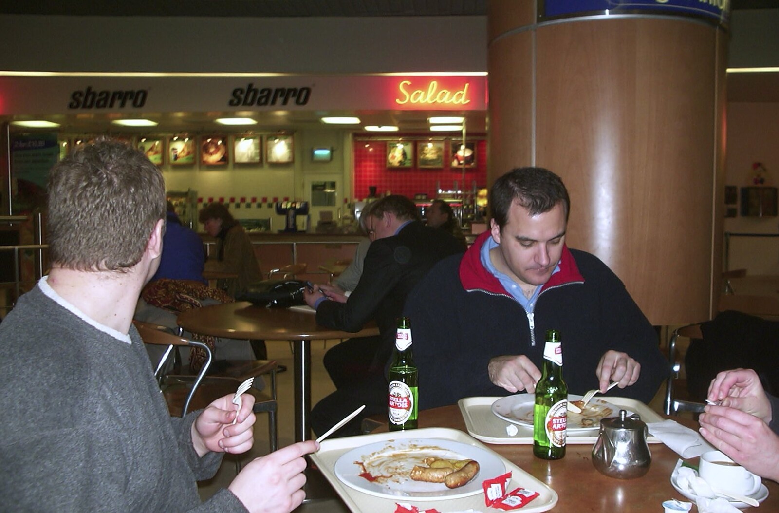 Adrian and Matt eat breakfast at Luton airport from 3G Lab Goes Skiing In Chamonix, France - 12th March 2002