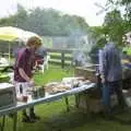 Wavy scopes out food, whilst Nigel helps out, A Rainy Barbeque at the Swan Inn, Brome, Suffolk - 15th June 2002