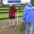 Spammy brings the parasol over to check the score, A Rainy Barbeque at the Swan Inn, Brome, Suffolk - 15th June 2002