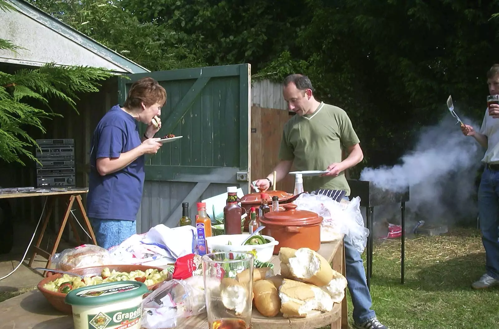 Pippa scoffs a burger, from DH's BSCC Barbeque, The Old Post Office, Brome, Suffolk - 7th July 2002