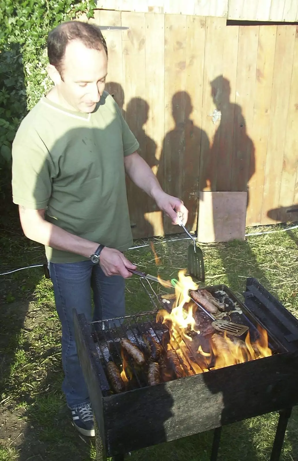 DH burns some food on the barbeque, from DH's BSCC Barbeque, The Old Post Office, Brome, Suffolk - 7th July 2002