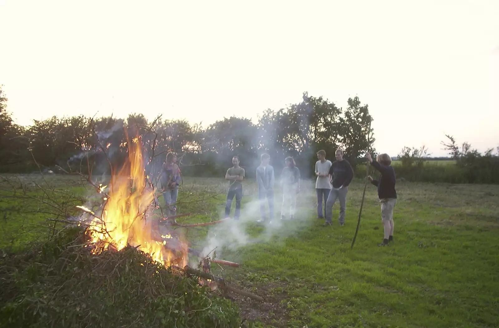 A crowd gathers around the bonfire, from DH's BSCC Barbeque, The Old Post Office, Brome, Suffolk - 7th July 2002