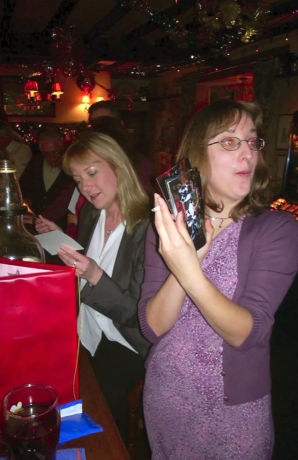 Caroline and Suey look at photos, from The BSCC Christmas Dinner, Brome Swan, Suffolk - 10th December 2002