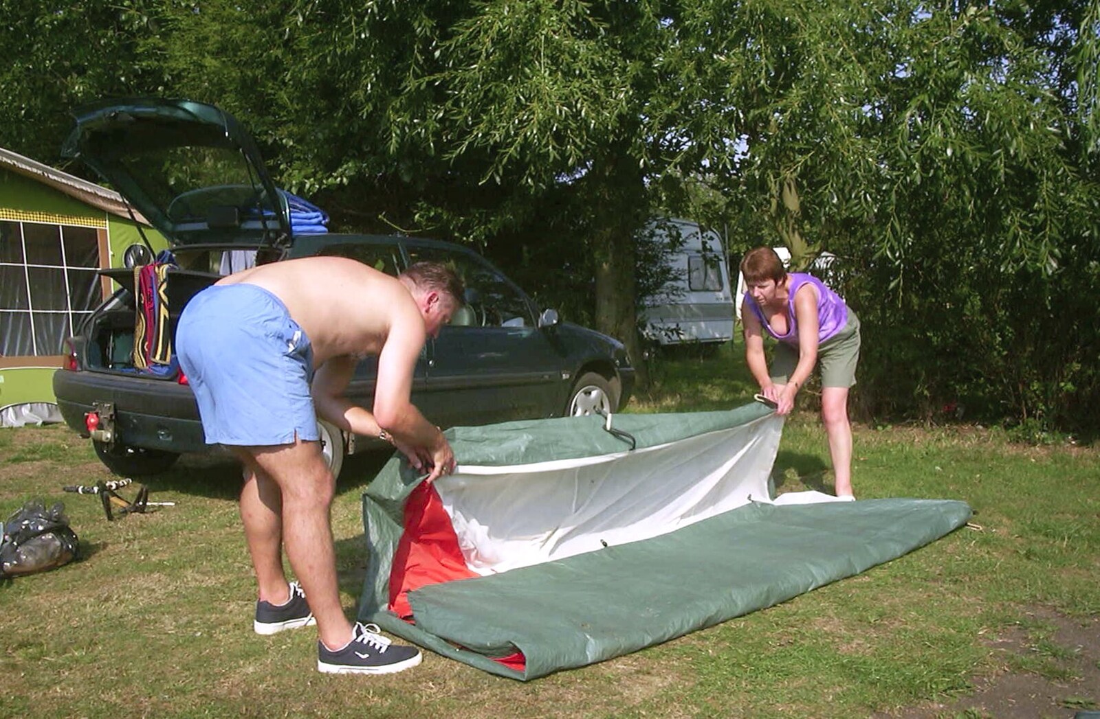 Nigel and Jenny roll their tent up from A BSCC Camping Trip to the Fox Inn, Shadingfield, Suffolk - 9th August 2003